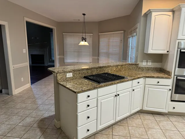 a kitchen with granite countertop white cabinets and white appliances