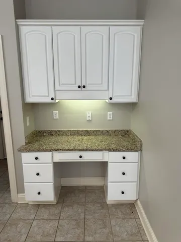 a kitchen with granite countertop white cabinets and sink