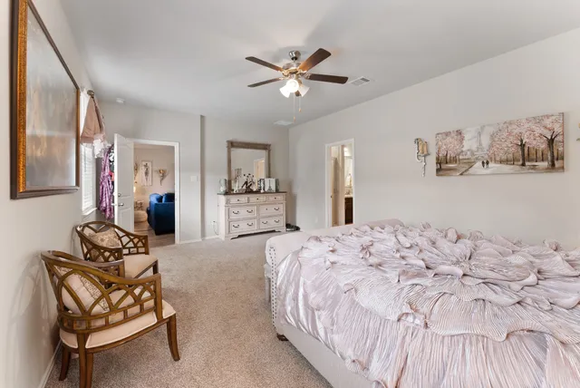 a spacious bedroom with a bed and ceiling fan
