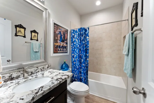 a bathroom with a granite countertop sink toilet and shower