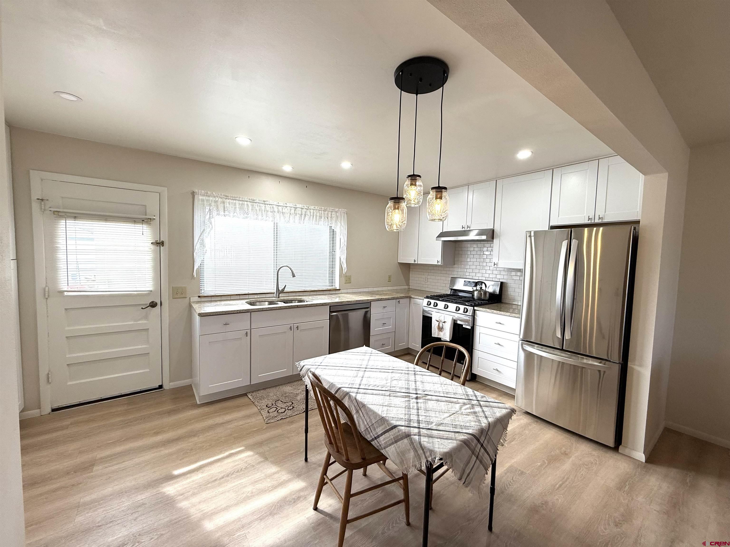 801 East 3rd Street Cortez, CO 81321 - Photo 9 of 22 a kitchen with refrigerator cabinets and wooden floor
