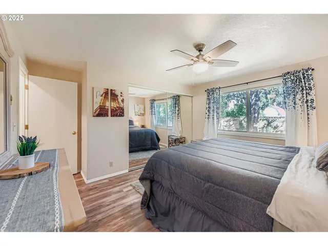 a bedroom with a large bed and wooden floor