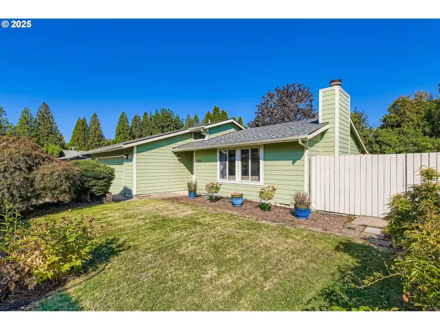 a view of a house with backyard and sitting area
