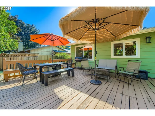 a view of a roof deck with table and chairs under an umbrella with wooden floor