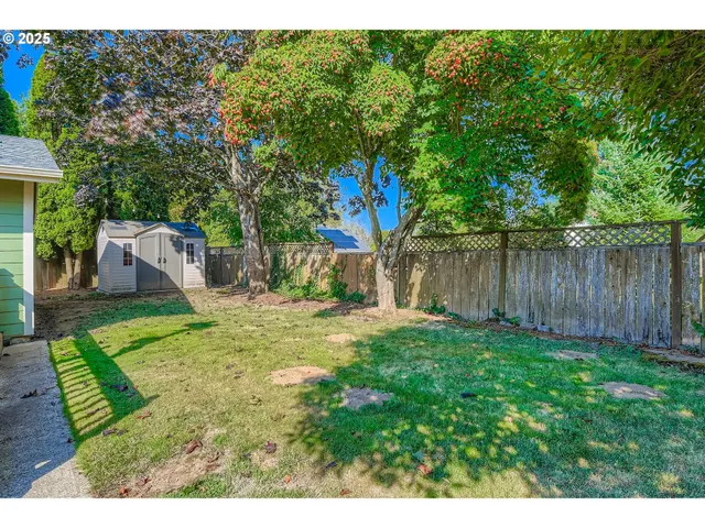 a view of a backyard with table and chairs and wooden fence