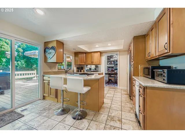 a kitchen with stainless steel appliances granite countertop a refrigerator and a stove top oven