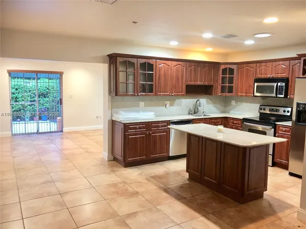 a kitchen with stainless steel appliances granite countertop a stove a sink dishwasher and a refrigerator