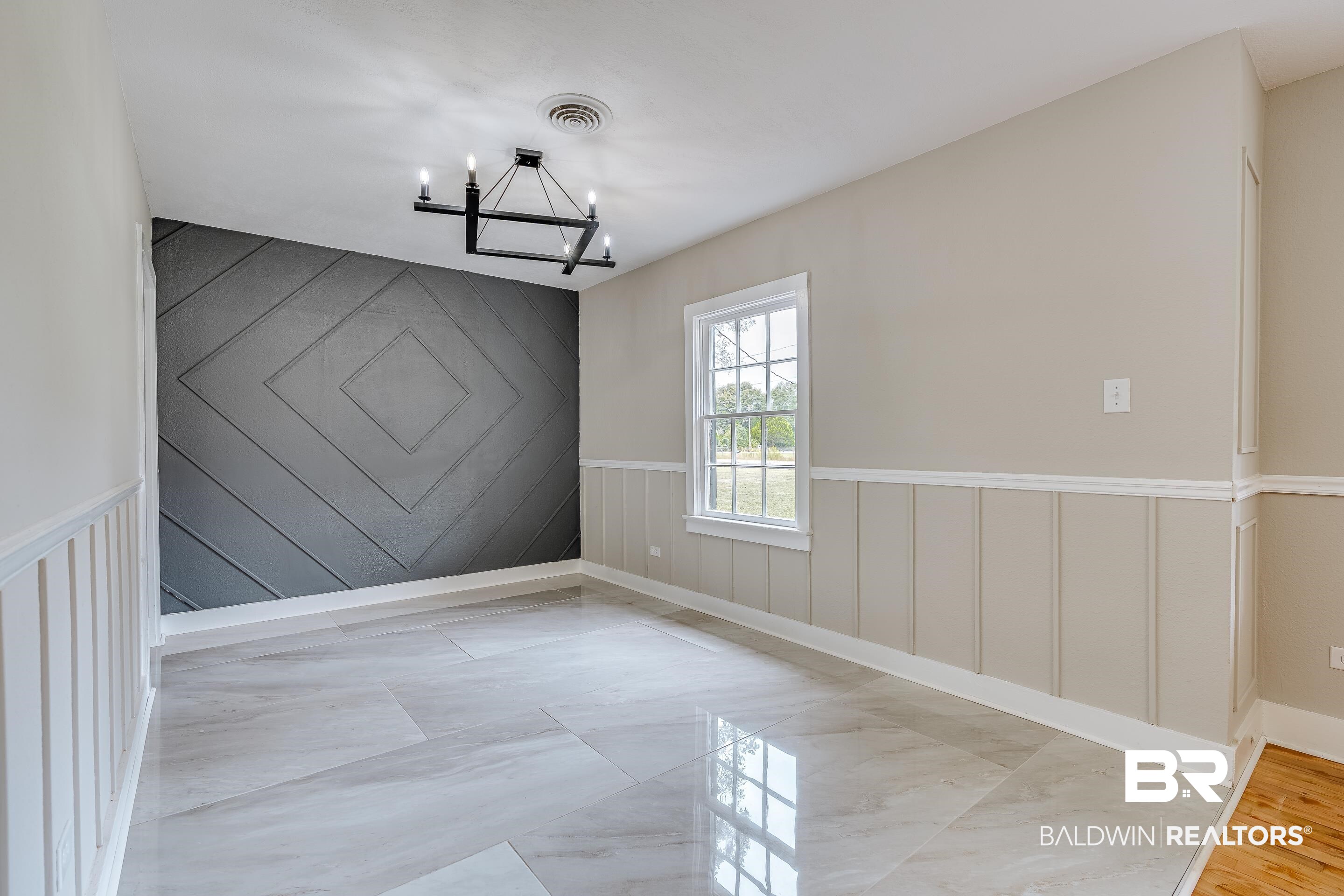 8001 16th Street Irvington, AL 36544 - Photo 9 of 35 Spare room with a wainscoted wall, a decorative wall, a chandelier, and light marble finish flooring