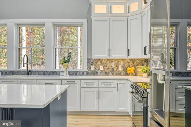 a view of an empty room with wooden floor and windows