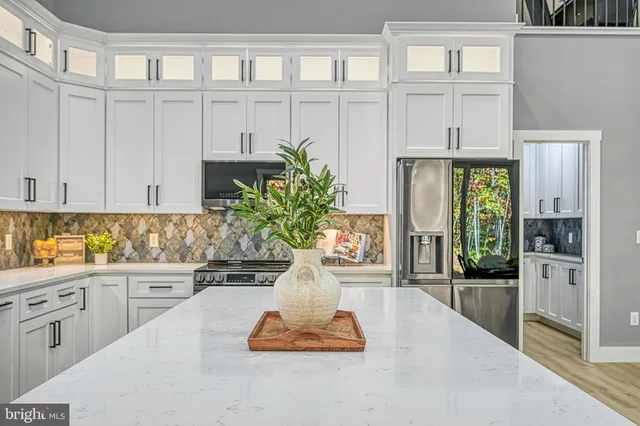 a living room with furniture a flat screen tv and kitchen view