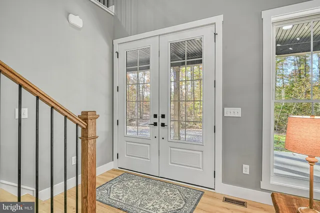 a view of a hallway with wooden floor and staircase