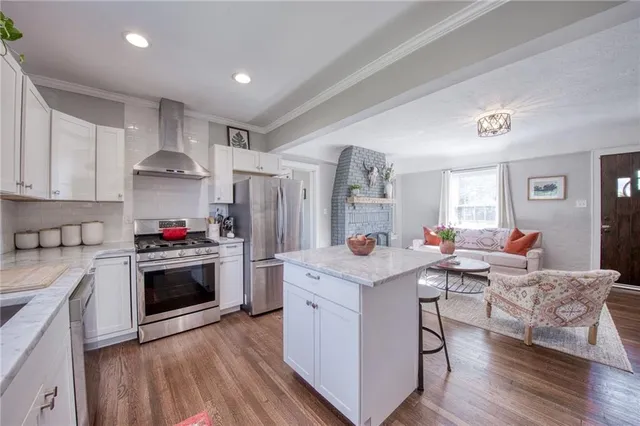 a kitchen with stainless steel appliances granite countertop a stove refrigerator and a refrigerator