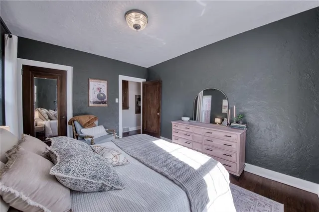 a bedroom with a large bed and wooden floor