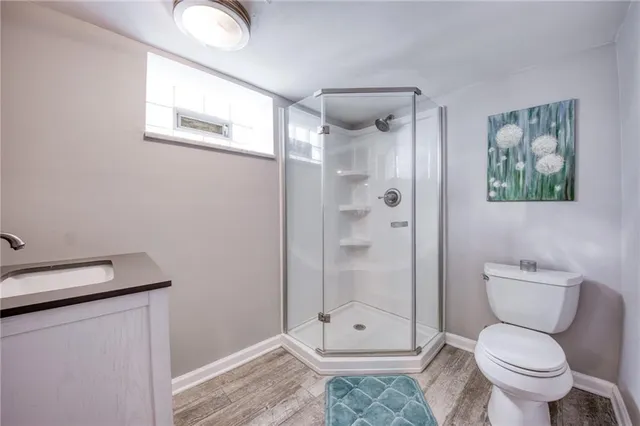 a bathroom with a granite countertop toilet a shower and a sink