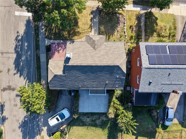 an aerial view of a house with a yard and tree s