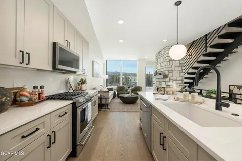a kitchen with a sink stove top oven and microwave