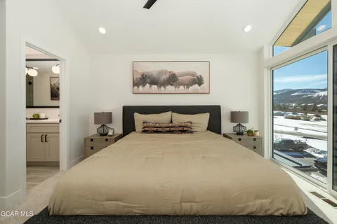 a bedroom with a bed and a large window