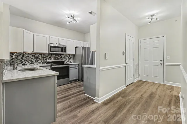 a kitchen with kitchen island a sink appliances and cabinets