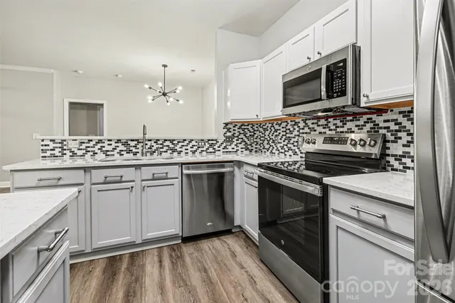 a kitchen with stainless steel appliances granite countertop a sink stove and microwave