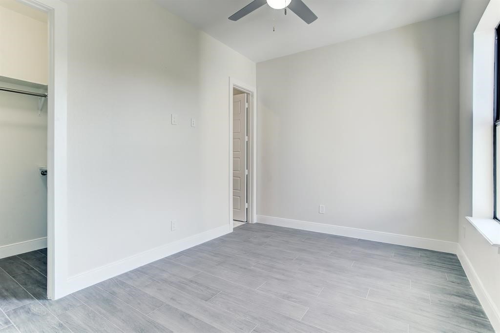 3106 Eunice Street Houston, TX 77009 - Photo 9 of 16 an empty room with wooden floor chandelier fan and windows