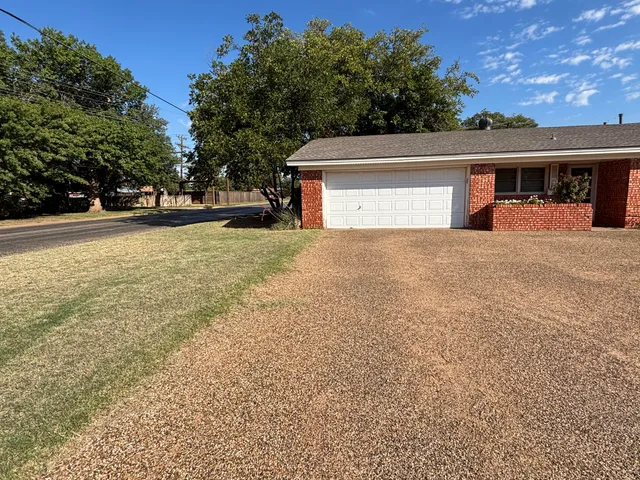 a view of house with yard and trees in the background