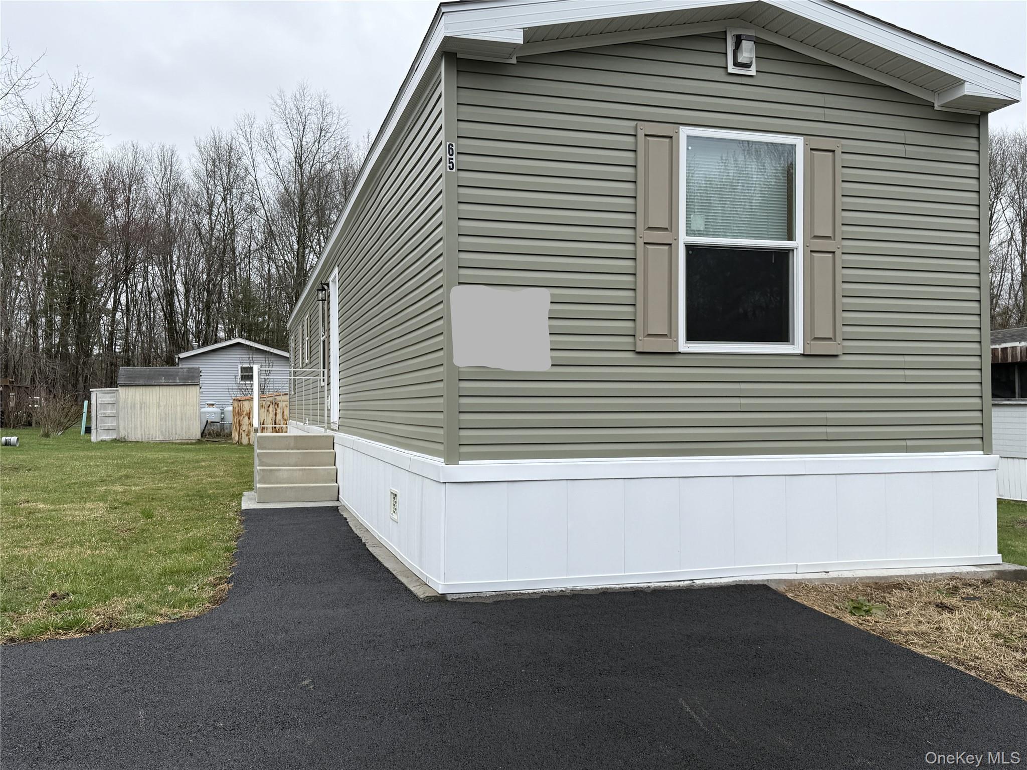View of side of home featuring an outbuilding and a yard