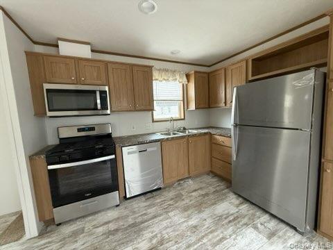 3146 Rte 9W, Unit 5A New Windsor, NY 12553 - Photo 7 of 20 Kitchen with brown cabinetry, ornamental molding, a sink, light wood-style flooring, and stainless steel appliances