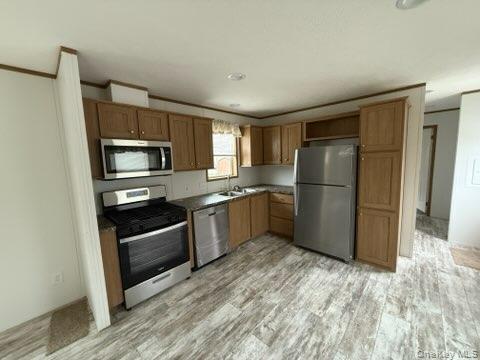 3146 Rte 9W, Unit 5A New Windsor, NY 12553 - Photo 9 of 20 Kitchen with ornamental molding, light wood-type flooring, brown cabinets, a sink, and appliances with stainless steel finishes