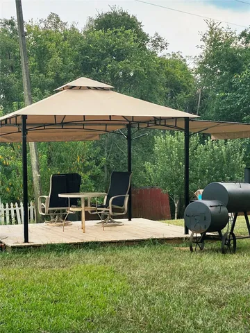 a backyard of a house with yard table and chairs