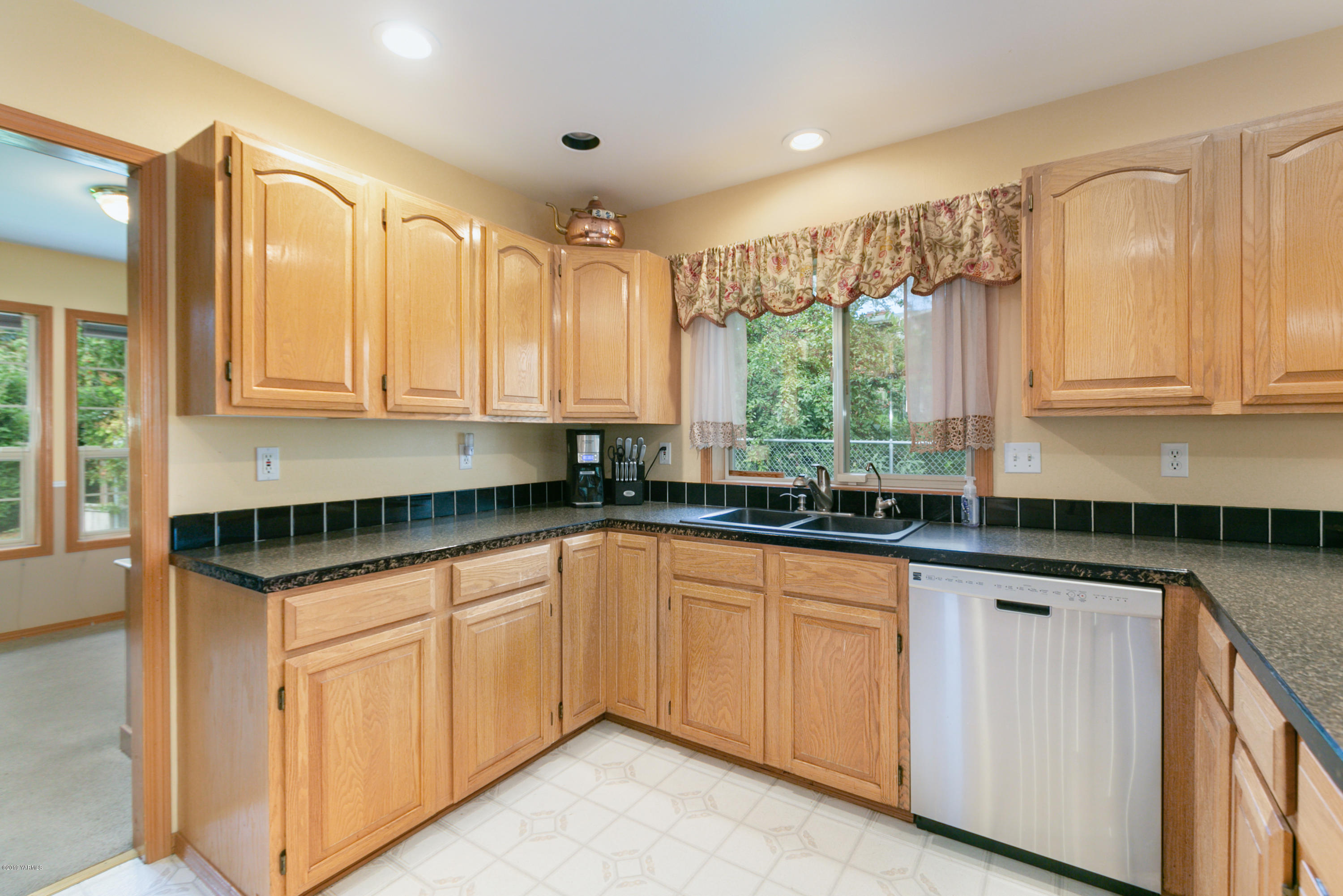 10501 Summitview Road Yakima, WA 98908 - Photo 11 of 22 a kitchen with granite countertop white cabinets white appliances and a sink