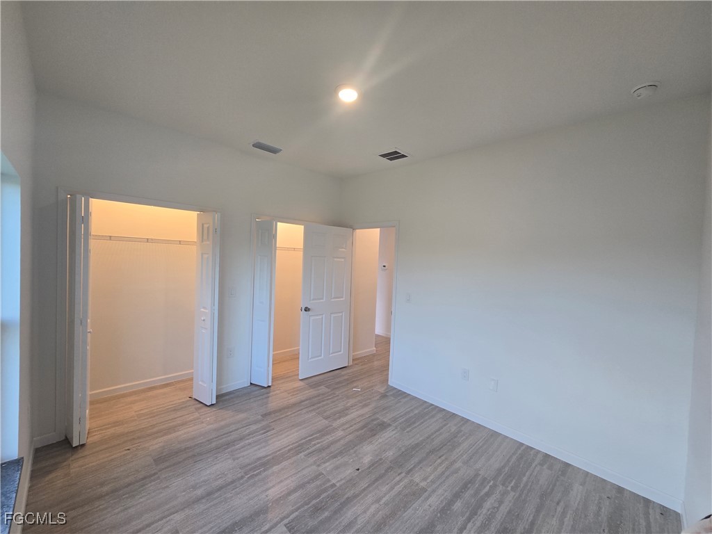 2822 19th Street Southwest Lehigh Acres, FL 33976 - Photo 12 of 23 a view of an empty room with wooden floor