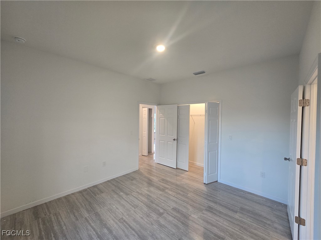 2822 19th Street Southwest Lehigh Acres, FL 33976 - Photo 15 of 23 a view of an empty room and wooden floor