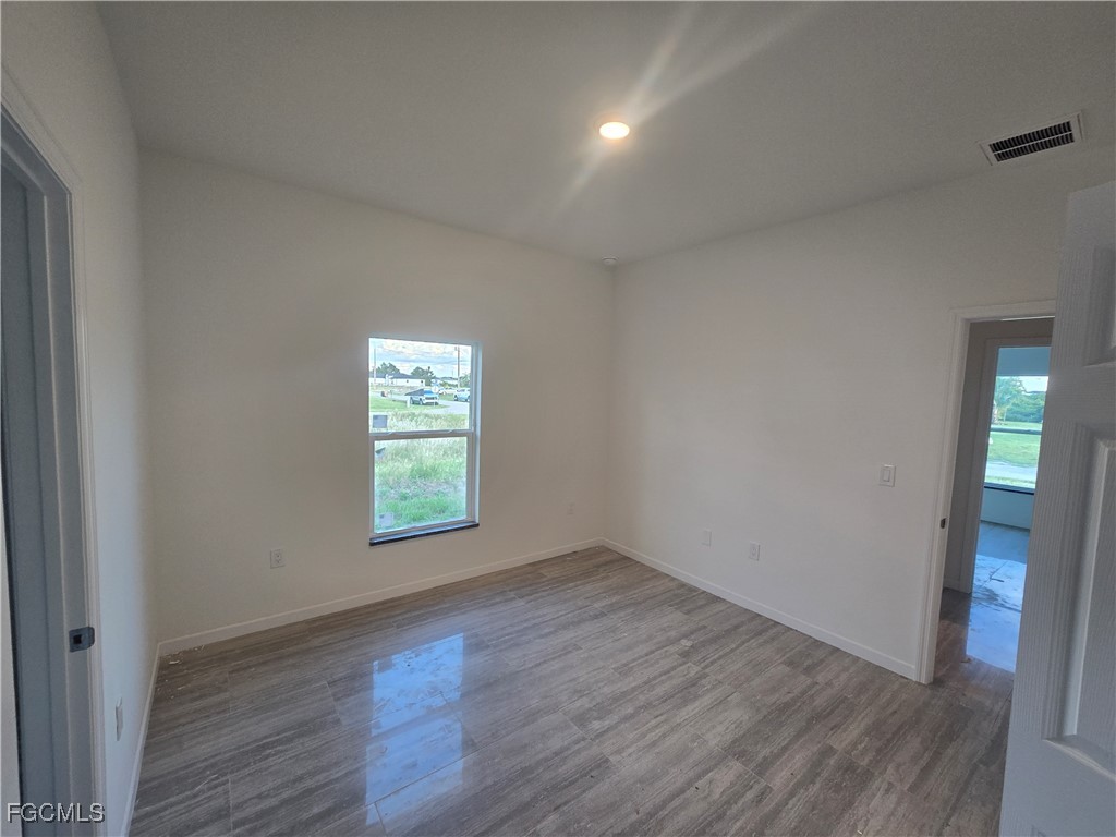 2822 19th Street Southwest Lehigh Acres, FL 33976 - Photo 17 of 23 an empty room with wooden floor and window