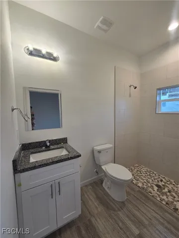 a bathroom with a granite countertop toilet and sink
