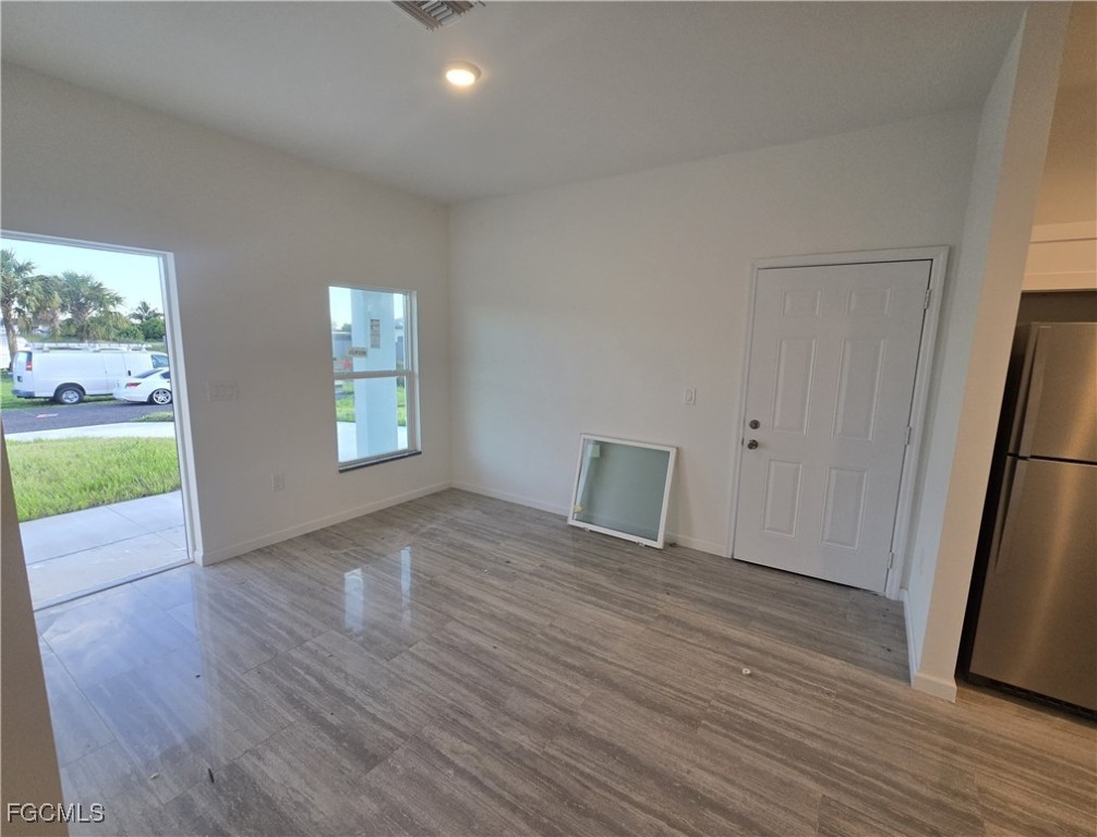 2822 19th Street Southwest Lehigh Acres, FL 33976 - Photo 4 of 23 an empty room with wooden floor and windows