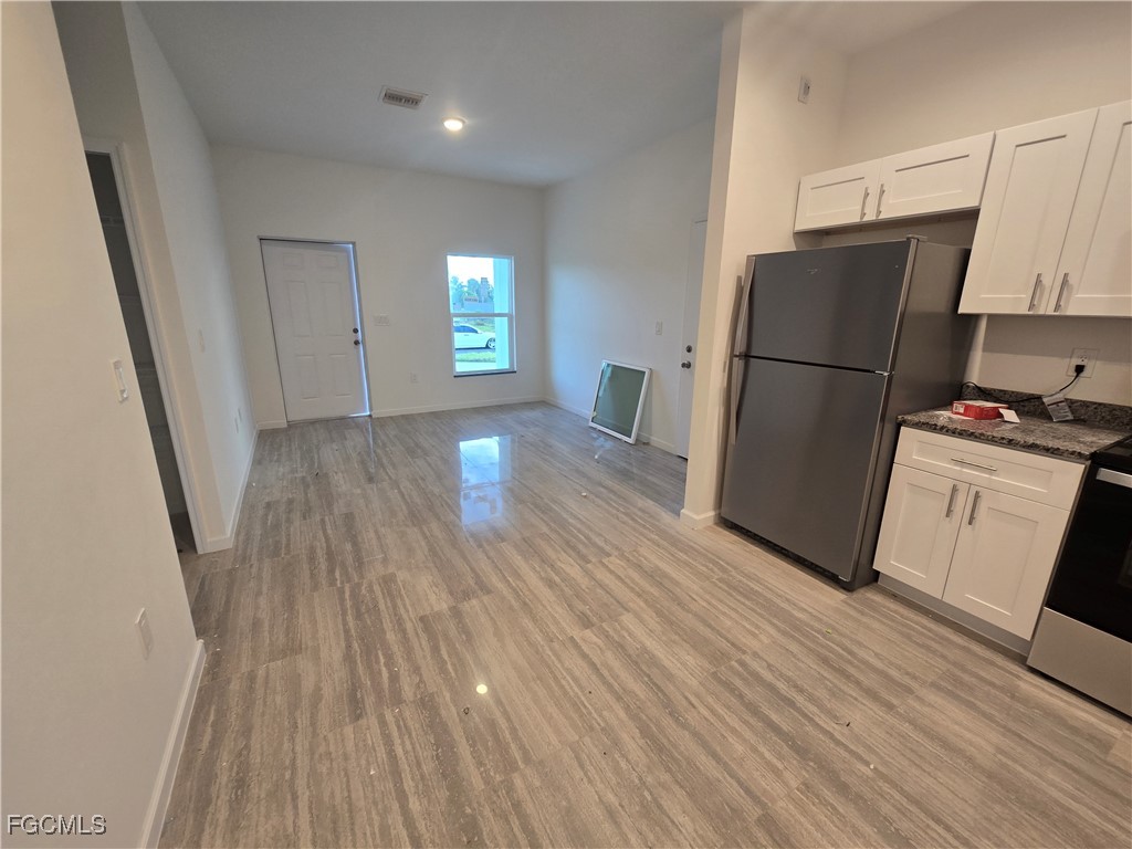 2822 19th Street Southwest Lehigh Acres, FL 33976 - Photo 5 of 23 a view of a kitchen with wooden floor and electronic appliances
