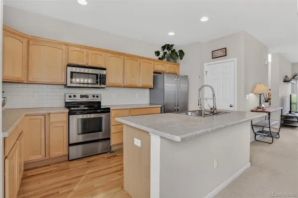 a kitchen with stainless steel appliances granite countertop a refrigerator a sink a stove a microwave and island