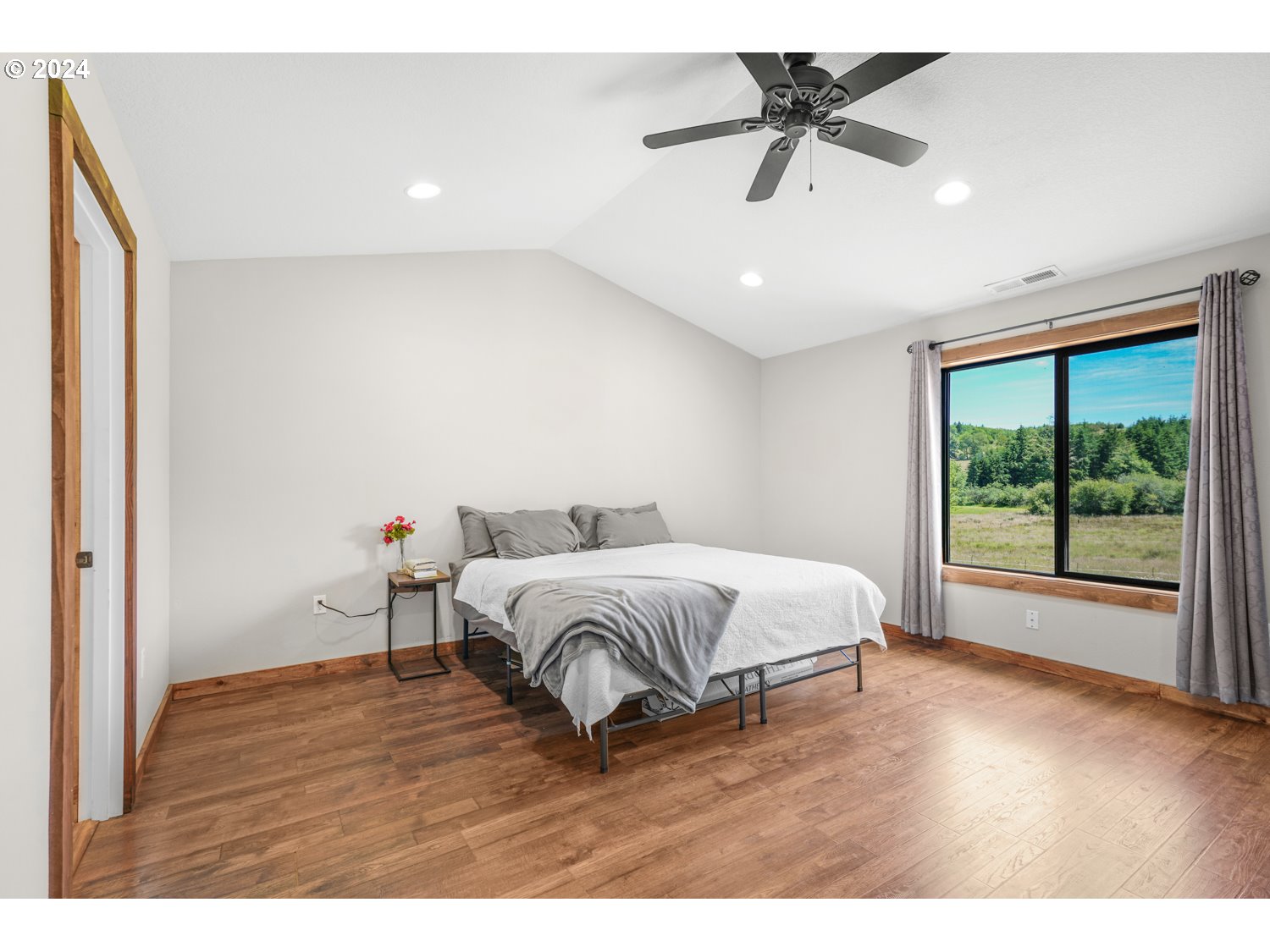 70200 Apiary Road Rainier, OR 97048 - Photo 16 of 37 a spacious bedroom with a bed and a chandelier