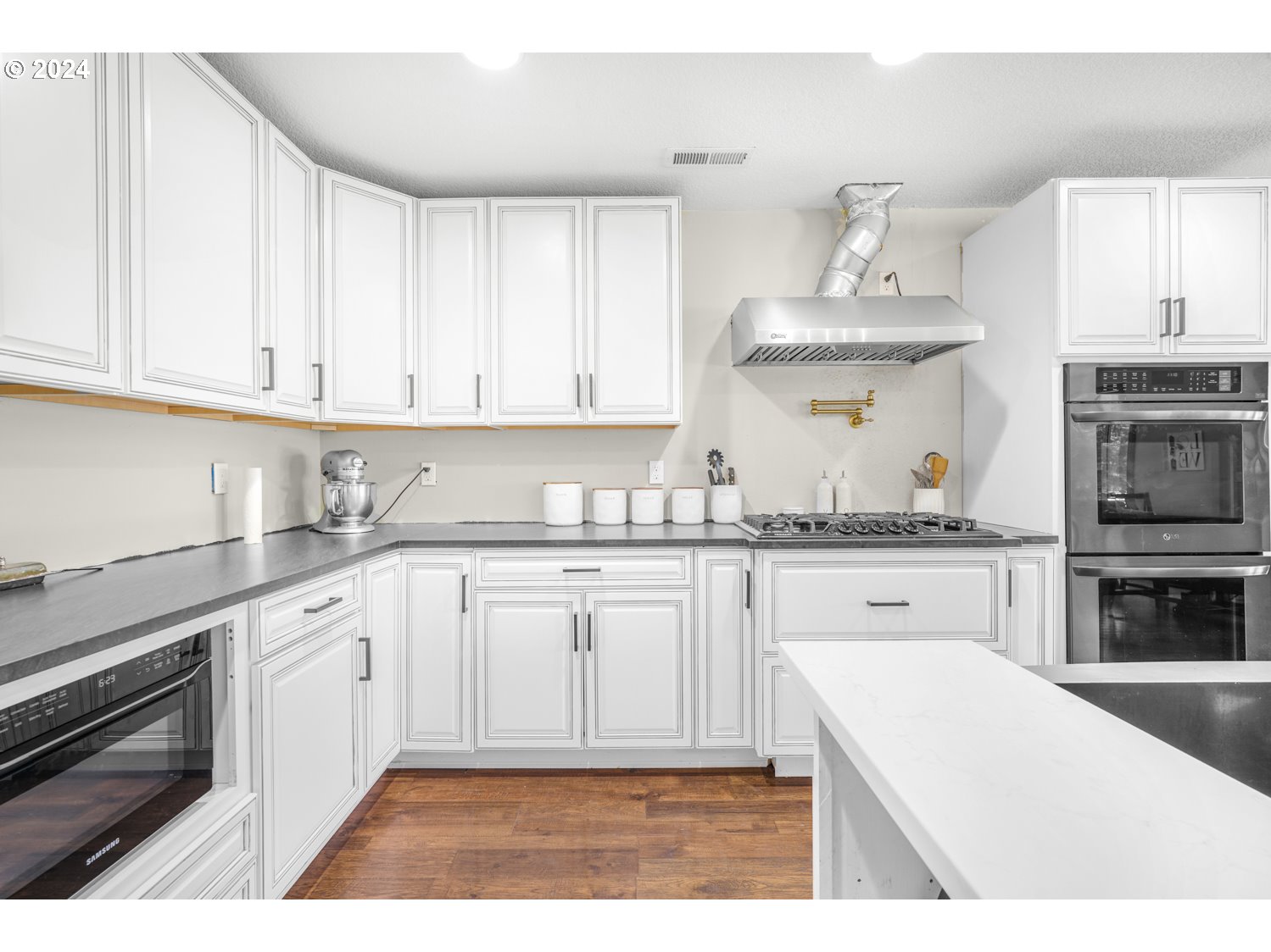 70200 Apiary Road Rainier, OR 97048 - Photo 9 of 37 a kitchen with granite countertop a stove and white cabinets