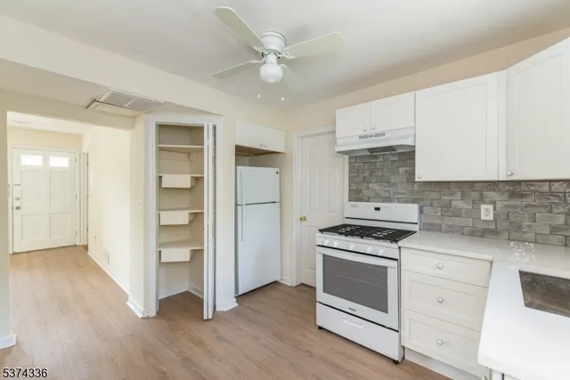 a kitchen with white cabinets and white appliances