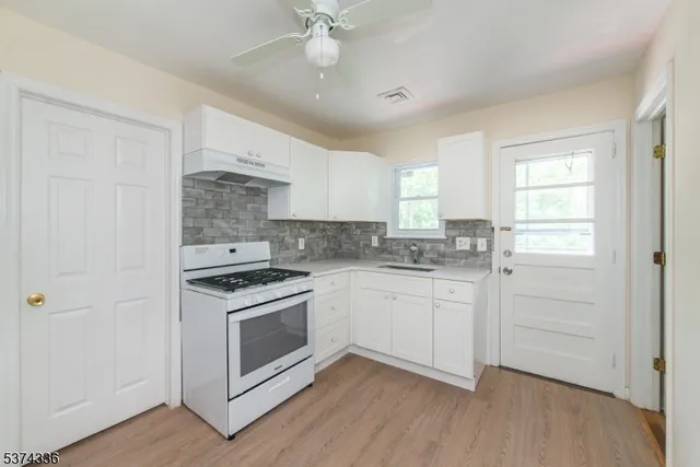 a kitchen with a stove oven and white cabinets