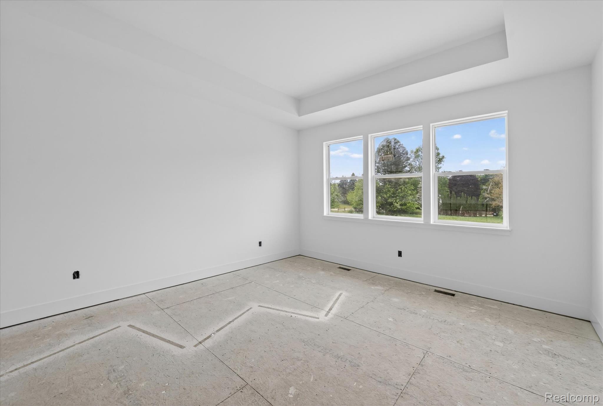 3297 Oak Grove Road Howell, MI 48855 - Photo 15 of 40 Spacious primary bedroom with tray ceiling and abundant natural light.