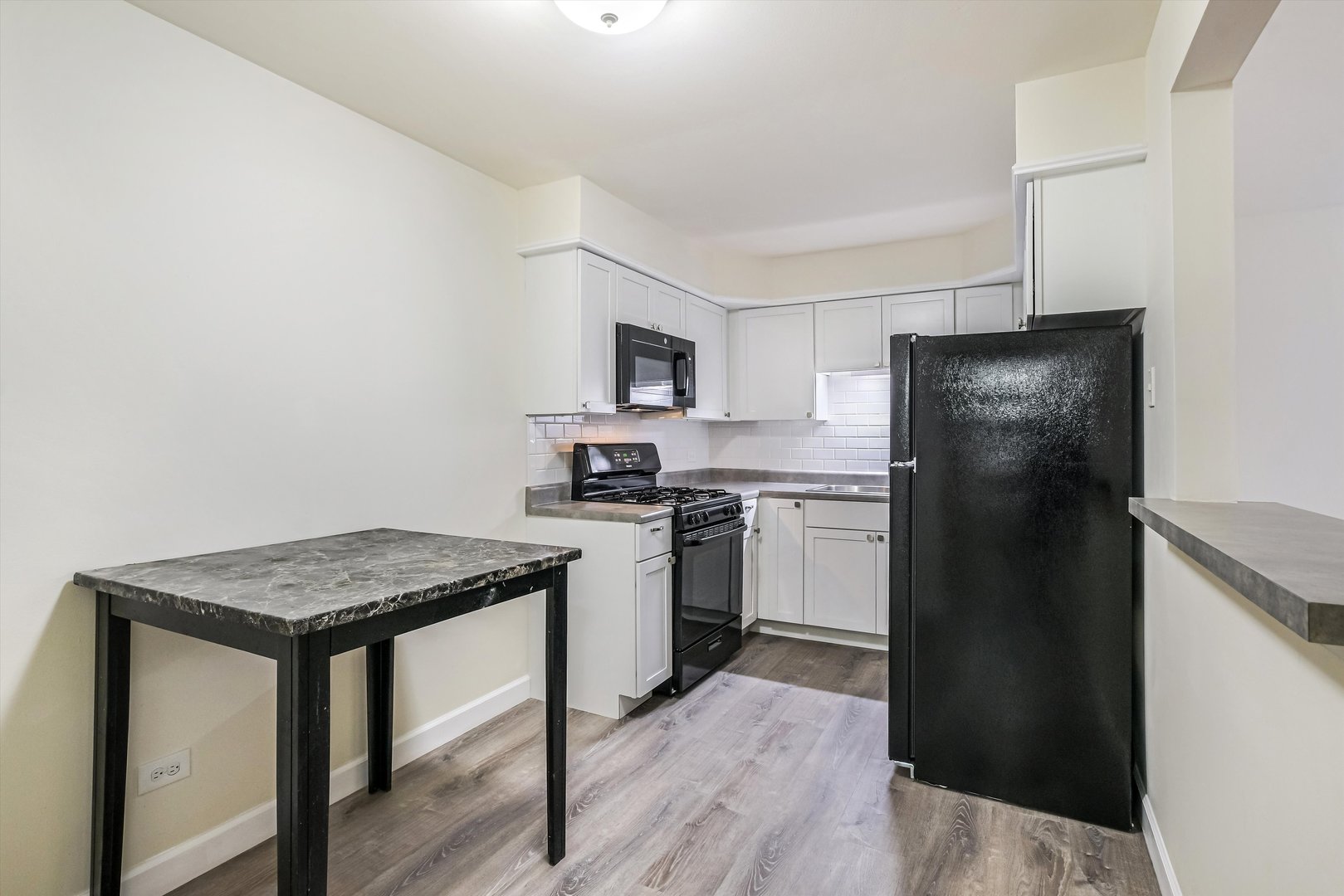 1039 College Avenue, Unit 2E Wheaton, IL 60187 - Photo 2 of 18 a kitchen with a refrigerator stove and sink