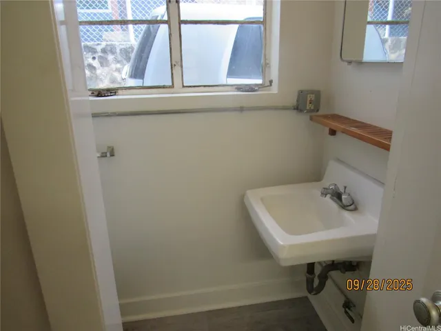 a bathroom with a sink a window and a toilet