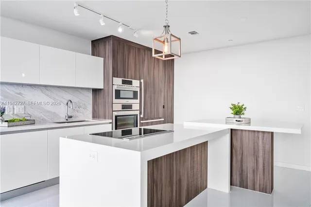 a kitchen with kitchen island a counter top space appliances and cabinets