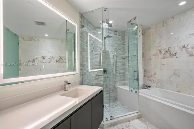 a bathroom with a granite countertop sink a toilet and shower