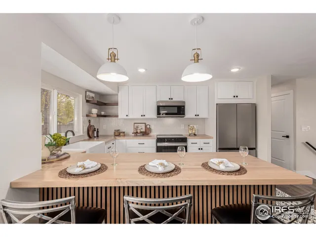 a kitchen with sink refrigerator dining table and chairs