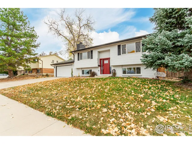 a front view of a house with large trees