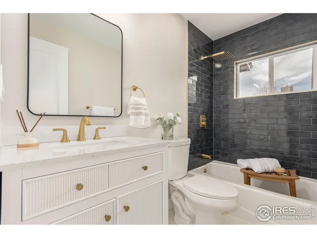 a bathroom with a granite countertop toilet sink and mirror