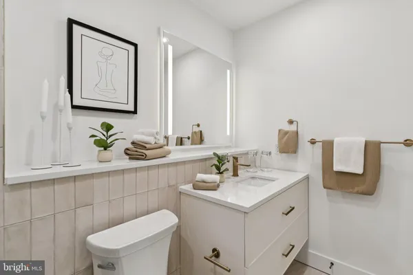 a bathroom with a sink a toilet and mirror